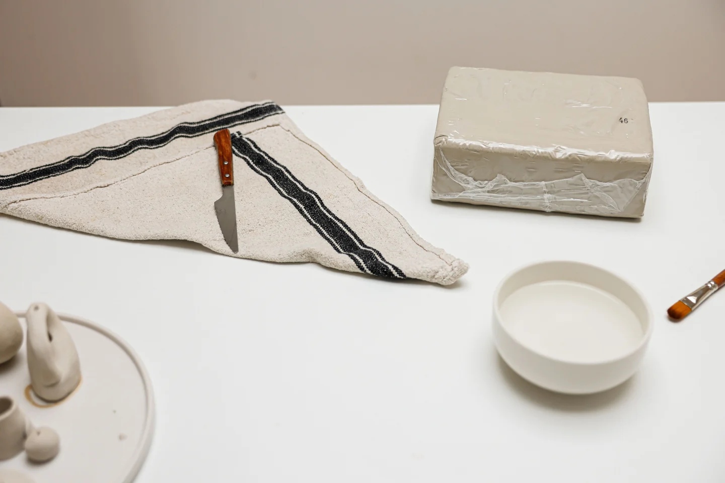 黏土块、碗与手工工具静物，美术主题配图，非 The Painter’s Loft 现场照片（课程示意图，非机构现场）